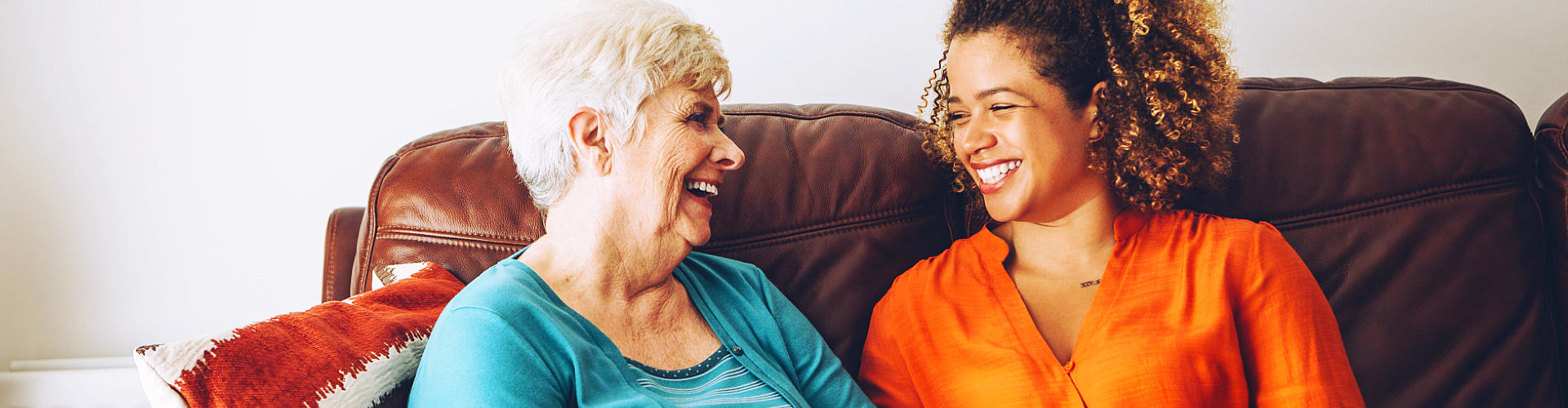 caregiver and old woman happily talking